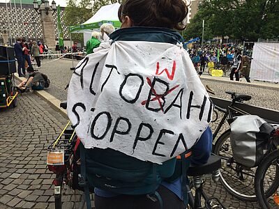 Demonstration gegen Autobahnbau mit selbstgemaltem „Plakat"